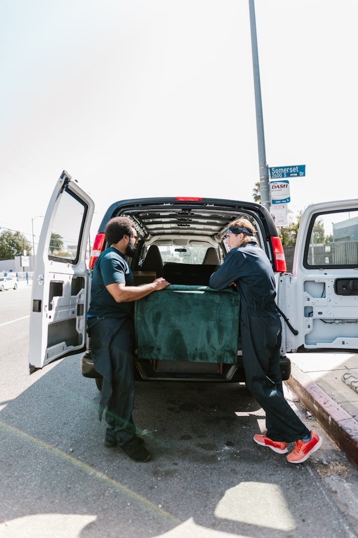 The Art of Drawing Readers In: Your attractive post title goes here Two movers load a van with furniture during moving day.